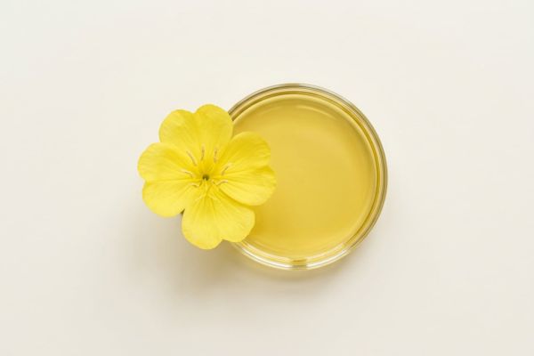 Gelbe Nachtkerzenblüte neben goldgelbem Nachtkerzenöl
